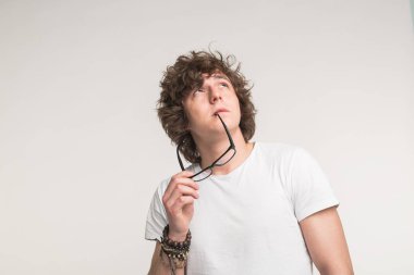 Genç yakışıklı çilli adam beyaz arka plan üzerinde düşünme