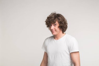 Poz ve hareket kopya alanı ile beyaz arka plan üzerinde beyaz t-shirt gülüyor yakışıklı delikanlı