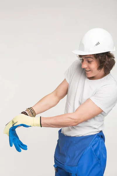 Portrait of happy builder in helmet wearing glove. — Stock Photo, Image