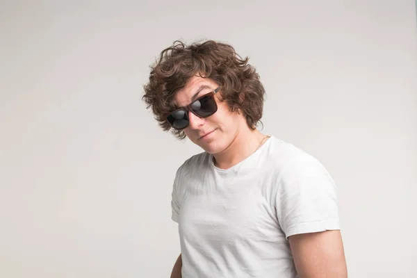 Portrait de mec cool en lunettes de soleil en t-shirt blanc sur fond blanc — Photo