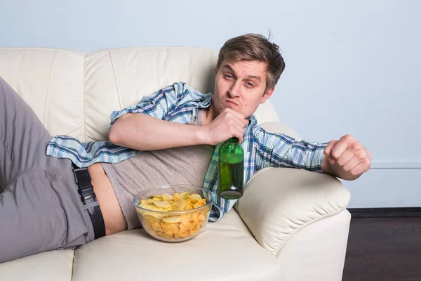 Muž s pivem a čipy, sledování tv doma — Stock fotografie