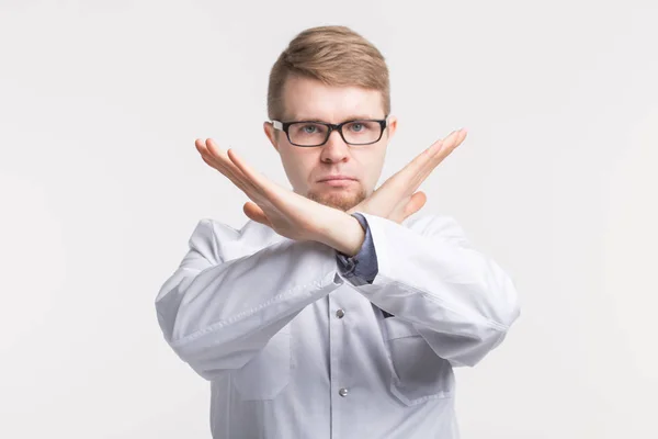 Joven médico masculino cruzando las manos en gesto prohibitivo — Foto de Stock