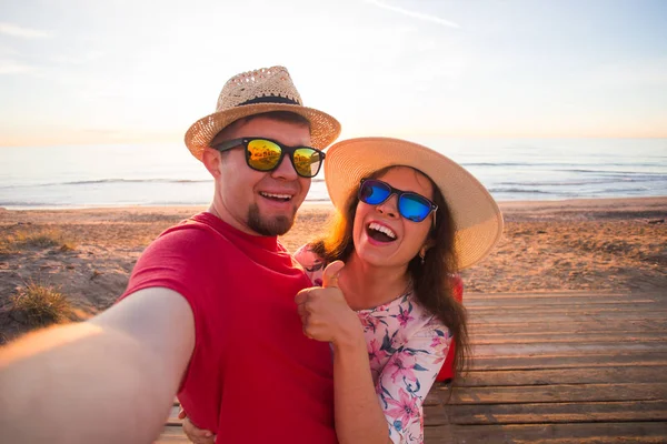 Cestování, dovolená a dovolená concept - hezká holka a její hezký kluk v slaměné klobouky, aby selfie — Stock fotografie