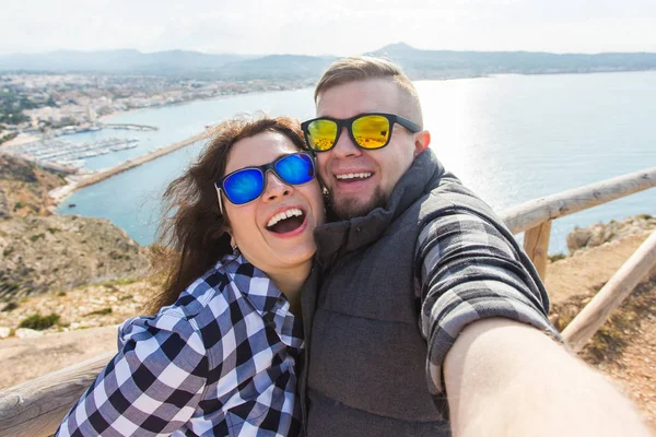 Voyage, vacances et concept de vacances - Beau couple s'amuser, prendre selfie, visages émotionnels fous et rire . — Photo