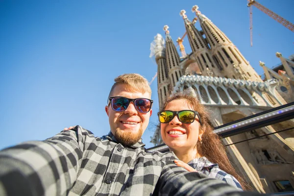 Travel, holidays and people concept - Happy couple taking selfie photo in front of the Sagrada Familia in Barcelona — Stock Photo, Image
