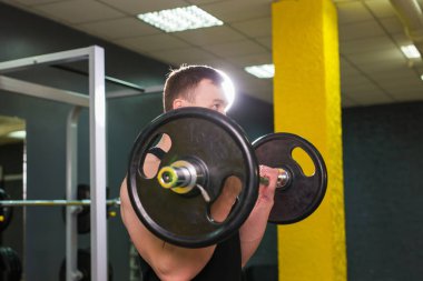 Spor salonunda ağırlık kas genç adam