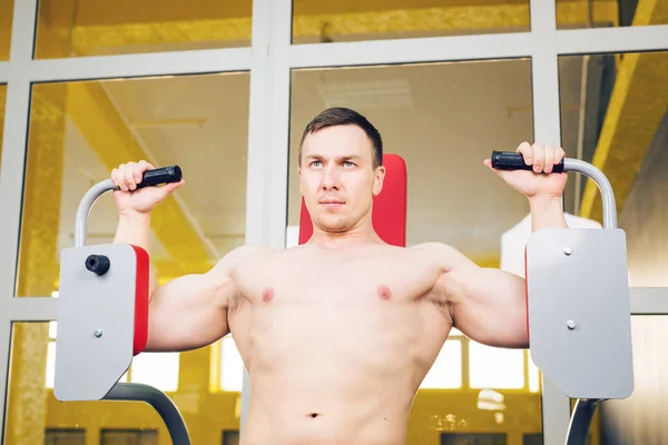 Fitness muž pracuje na stroji motýl v tělocvičně — Stock fotografie