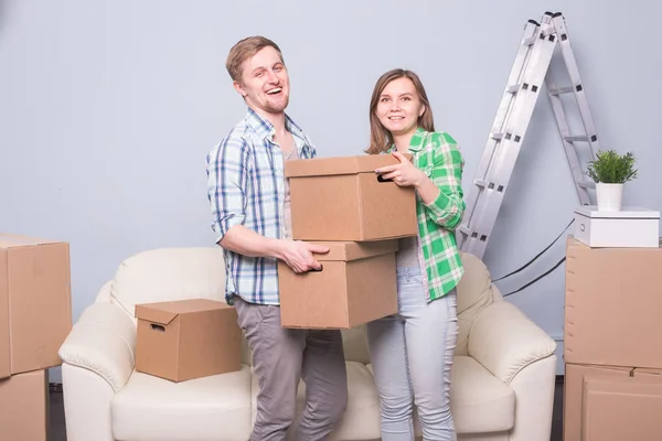 Família, novo apartamento, emoções e conceito comovente - casal de jovens felizes empilham sua caixa juntos por causa de se mudar para um novo apartamento e sorrir — Fotografia de Stock