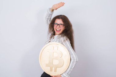 Cryptocurrency, sanal para ve blockchain kavramı - genç komik kadın büyük bir altın bitcoin elinde tutar..