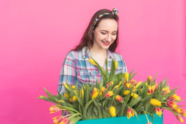 Esmer genç kadın çiçekçi lale pembe bir arka plan üzerinde grup ile