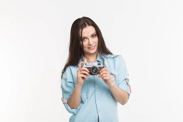 Photographer, hobby and people concept - Young brunette woman with retro camera on white background — Stok Foto