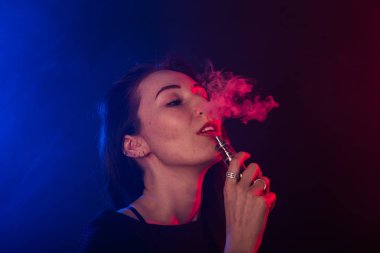 Neon kırmızı ve mavi genç kadın portresi ile vape ya da e-sigara duman
