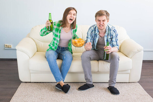 Sad friends or football fans watching soccer on tv. Losing a favorite team