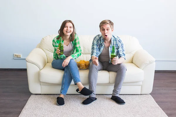 Casal de amigos sentados no sofá assistindo jogo esporte na tv — Fotografia de Stock