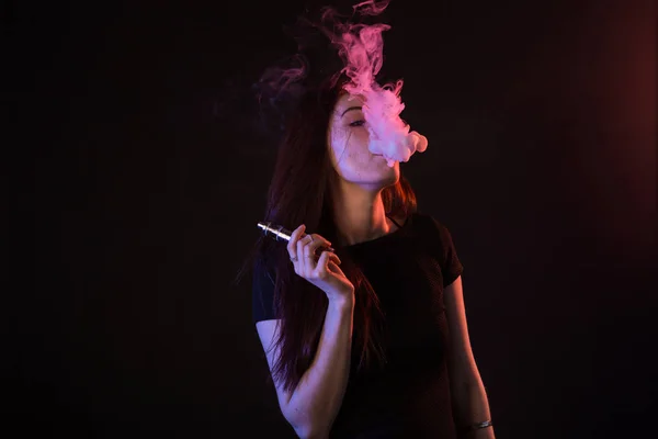 Genç kadın sigara vape veya e-sigara neon ışık — Stok fotoğraf