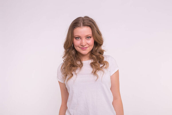 Fashion, style and people concept - pretty young woman dressed in white shirt over white background