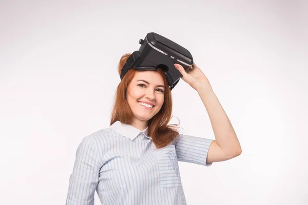 VR, teknolojiler, insan kavramı - sanal gerçeklik gözlük ve gülümsüyor beyaz arka plan üzerinde seyir sürpriz genç kadın. — Stok fotoğraf