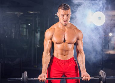 Yakışıklı güç halter atletik adamla. Altı paket, mükemmel abs, omuzlar, pazı, triceps ve göğüs ile güçlü vücut geliştirmeci