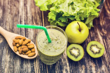 Kivi ile sağlıklı yeşil güler yüzlü, rustik ahşap arka plan üzerinde elma.