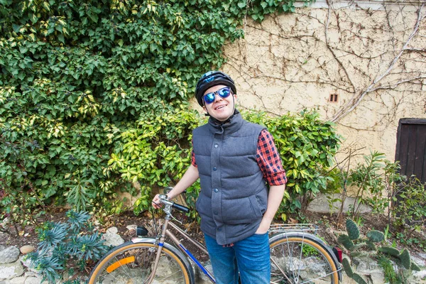 Όμορφος άντρας ποδηλάτης στην ποδηλασία ρούχα και ποζάρουν κοντά σε βλέπουν τα φωτογραφικών μηχανών, ποδηλάτων κράνος χαμογελώντας — Φωτογραφία Αρχείου