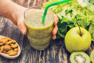 Kivi ile sağlıklı yeşil güler yüzlü, rustik ahşap arka plan üzerinde elma.