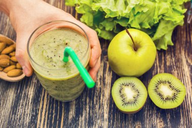 Kivi ile sağlıklı yeşil güler yüzlü, rustik ahşap arka plan üzerinde elma.