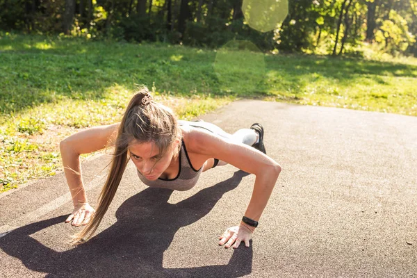 Donna in forma facendo flessioni al parco . — Foto Stock