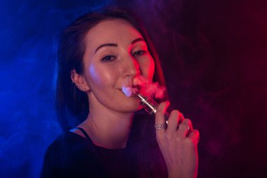 Genç kadın sigara vape veya e-sigara neon ışık