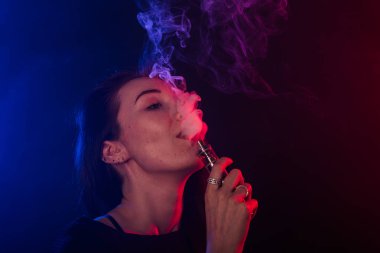 Kırmızı ve mavi neon ışık siyah t-shirt vaping genç kadın