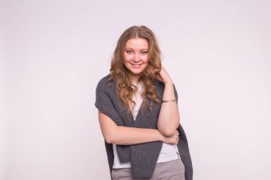 Kıvırcık saçlı beyaz zemin üzerine hırka giymiş güzel Avrupa kadın