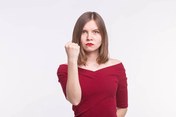 Retrato de una joven enojada mostrando un puño en la parte superior roja . — Foto de Stock