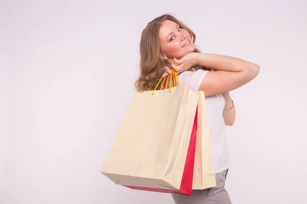 Mulher sorridente com sacos de compras no fundo branco — Fotografia de Stock