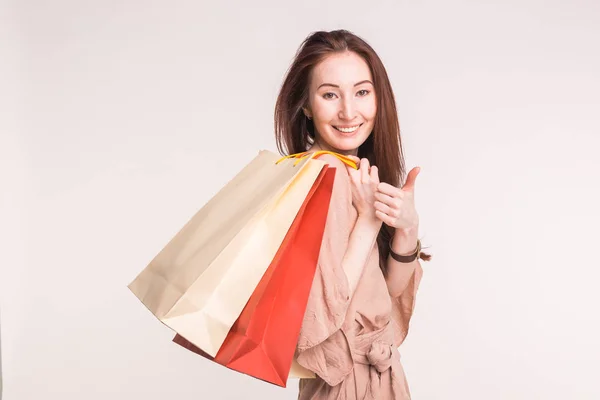 Gente, venta y concepto de consumismo - Mujer asiática feliz sobre fondo blanco sosteniendo bolsas de compras — Foto de Stock