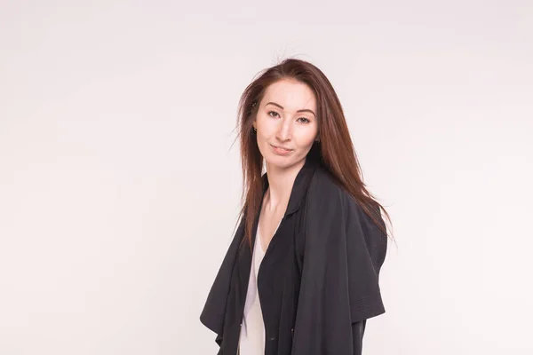 Junge asiatische Frau in schwarzem Mantel auf weißem Hintergrund mit Kopierraum — Stockfoto