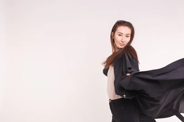 Portrait of fashionable beautiful asian girl in motion in black over white background with copy space — Stock Photo, Image