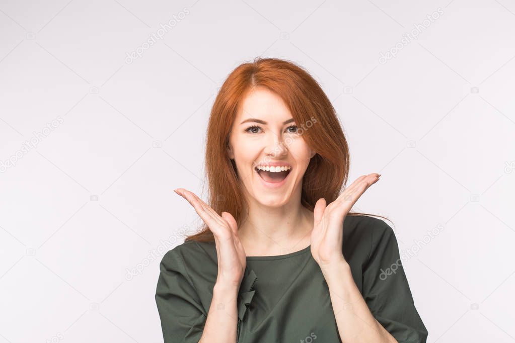 Surprised redhead woman on white background