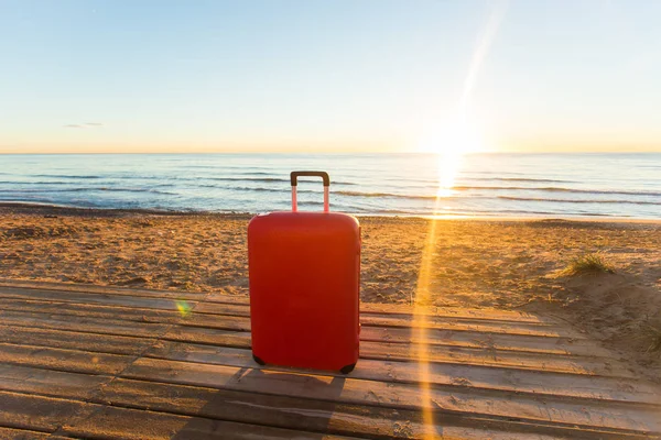 Bagaj, tatil, seyahat kavramı - kırmızı bavul ayakta denize yakın — Stok fotoğraf