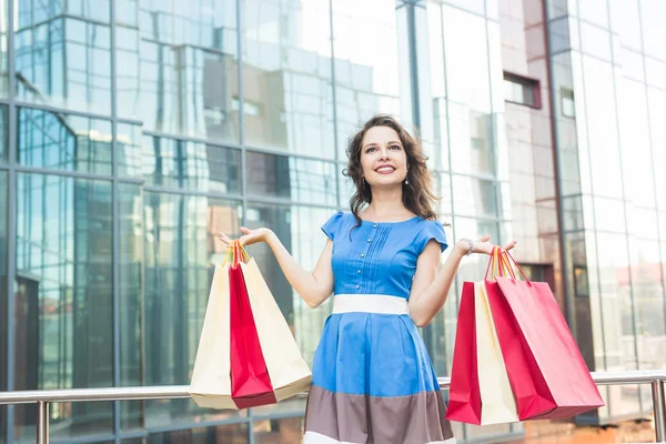 happiness, consumerism, sale and people concept - woman with shopping bags.