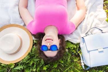Yaz, tatil ve eğlence kavramı - en iyi genç komik kadın parkta çim üzerinde yalan güneş gözlüğü takıyor portresi