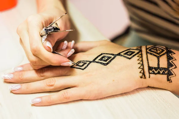 Giovane donna mehendi artista pittura hennè sulla mano . — Foto Stock
