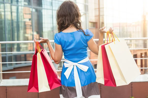 Kauf-, Verkaufs- und Personenkonzept - Rückansicht einer jungen Frau mit Einkaufstaschen — Stockfoto
