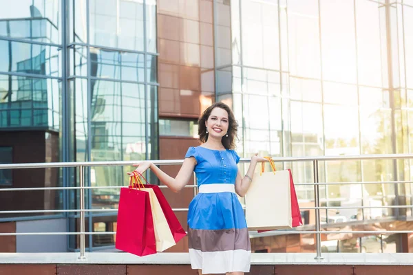 Konsum, Verkauf und Menschen-Konzept - junge Frau trägt Einkaufstüten beim Spazierengehen auf der Straße — Stockfoto
