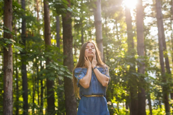 Natuur, zomer en mensen concept - jonge vrouw poseren in het groene woud — Stockfoto