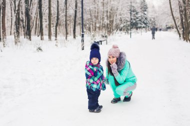Aile, veli ve eğlence kavramı - eğleniyor ve kış parkta oynarken anne ve çocuk kız