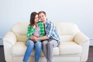 Genç çift gülüyor ve kanepeye sarılma eğleniyor