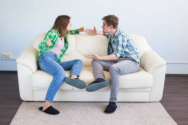 Pelea, conflicto y concepto de personas - Mujer haciendo gesto mientras discute con su pareja en la sala de estar —  Fotos de Stock
