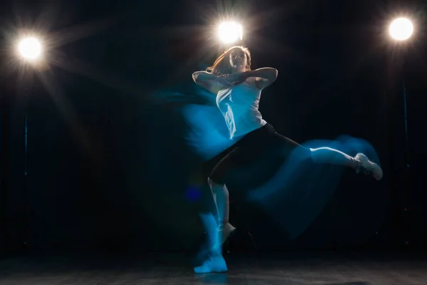 Baile, deporte, hermoso y concepto de la gente - mujer joven bailando en la oscuridad saltó en la luz colorida — Foto de Stock