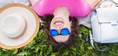 Yaz, tatil ve eğlence kavramı - en iyi genç komik kadın parkta çim üzerinde yalan güneş gözlüğü takıyor portresi