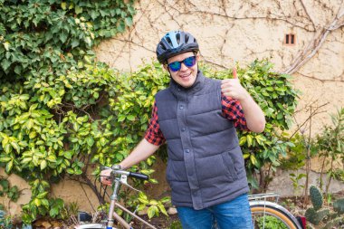 Başparmak parkta güneşli günde gösterilmesini bisiklet ile yakışıklı genç