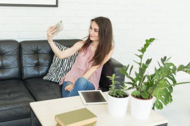 Teknoloji, fotoğraf ve insanlar kavramı - karanlık kanepede bir selfie alarak güzel genç kadın portresi